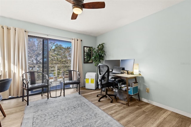 home office with light wood finished floors, baseboards, and a ceiling fan