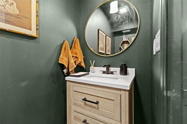 bathroom with a textured wall and vanity