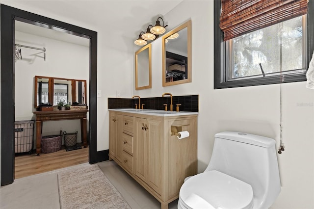 bathroom with tasteful backsplash, vanity, toilet, and tile patterned floors