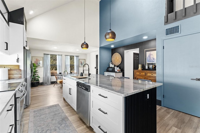 kitchen with appliances with stainless steel finishes, a sink, visible vents, and light wood-style floors