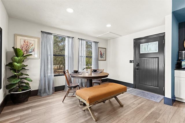 dining area featuring recessed lighting, light wood-style flooring, baseboards, and a textured ceiling