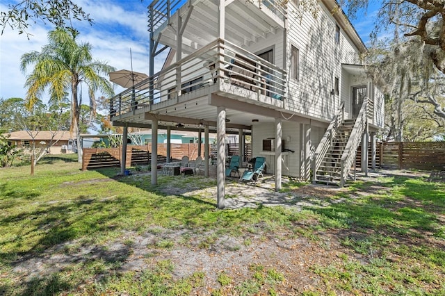 back of house with a deck, a yard, stairway, and fence