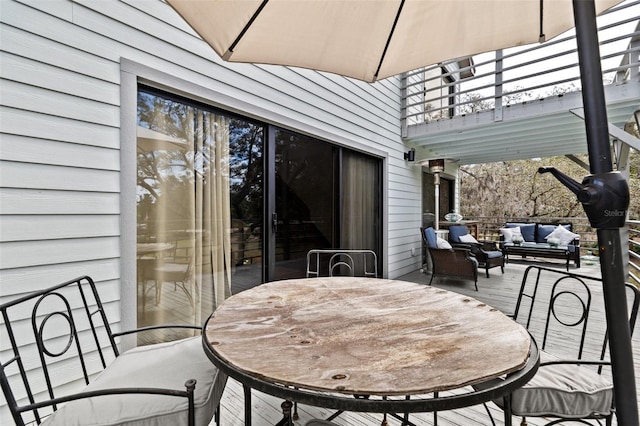 wooden terrace with outdoor dining space and an outdoor living space