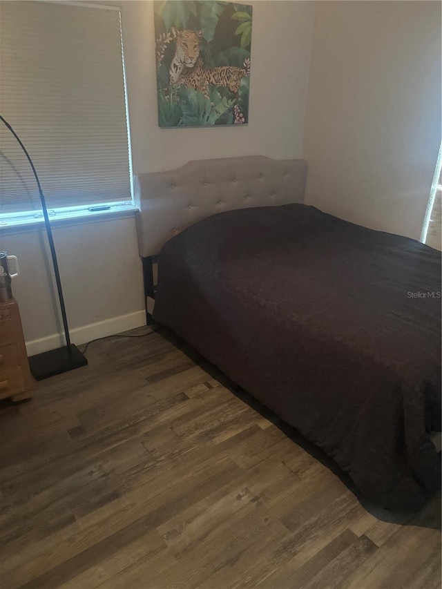 bedroom with baseboards and wood finished floors