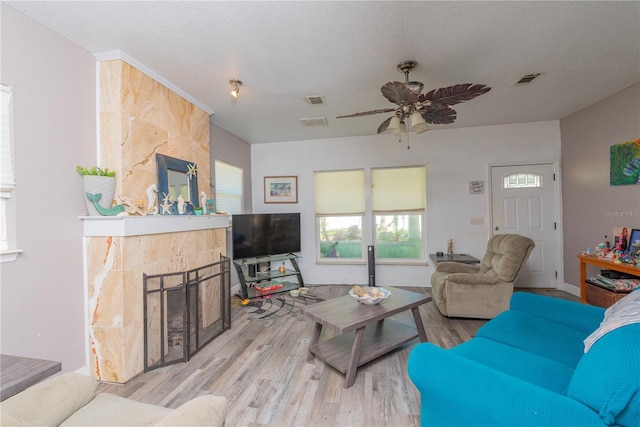 313 Jefferson Ave S, Oldsmar, FL 34677 - living area with ceiling fan, wood finished floors, visible vents, and a tile fireplace