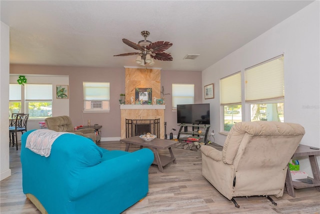 313 Jefferson Ave S, Oldsmar, FL 34677 - living room with visible vents, ceiling fan, baseboards, a tiled fireplace, and light wood-style floors
