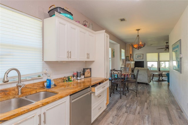 313 Jefferson Ave S, Oldsmar, FL 34677 - kitchen with white cabinetry, light wood-style flooring, a sink, stainless steel dishwasher, and open floor plan