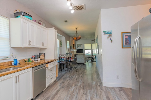 313 Jefferson Ave S, Oldsmar, FL 34677 - kitchen with visible vents, appliances with stainless steel finishes, white cabinetry, and light wood-style floors
