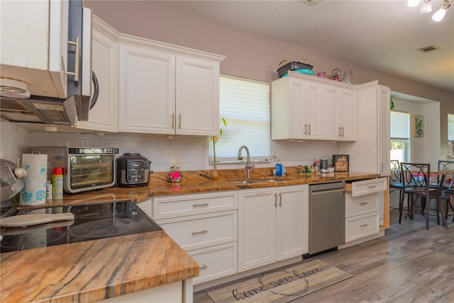 313 Jefferson Ave S, Oldsmar, FL 34677 - kitchen featuring backsplash, dishwasher, light wood-style flooring, white cabinetry, and a sink