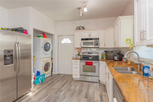 313 Jefferson Ave S, Oldsmar, FL 34677 - kitchen with a sink, backsplash, stainless steel appliances, white cabinets, and stacked washer / drying machine