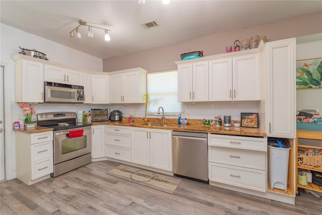 313 Jefferson Ave S, Oldsmar, FL 34677 - kitchen featuring visible vents, light wood-style flooring, stainless steel appliances, and a sink