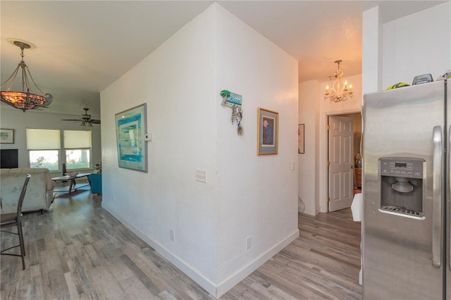 313 Jefferson Ave S, Oldsmar, FL 34677 - hall featuring baseboards, light wood-style floors, and a chandelier