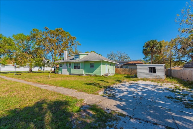 313 Jefferson Ave S, Oldsmar, FL 34677 - view of front of home featuring a front lawn, fence, an outdoor structure, and a chimney