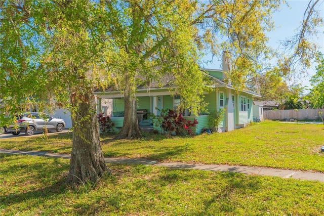313 Jefferson Ave S, Oldsmar, FL 34677 - view of front of property with a chimney, a front yard, and fence