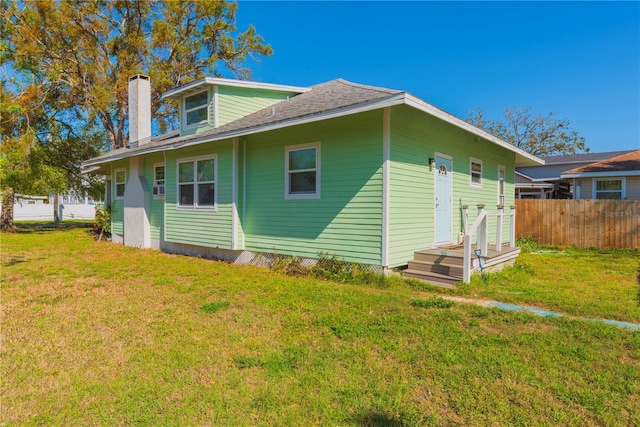 313 Jefferson Ave S, Oldsmar, FL 34677 - rear view of house with fence, a lawn, and a chimney