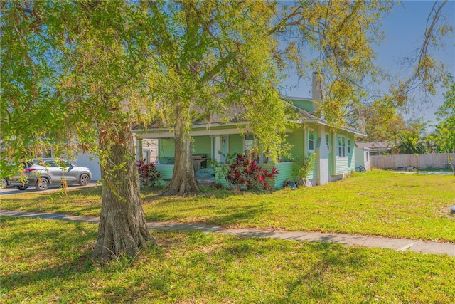 313 Jefferson Ave S, Oldsmar, FL 34677 - view of front facade with covered porch, a front lawn, and fence