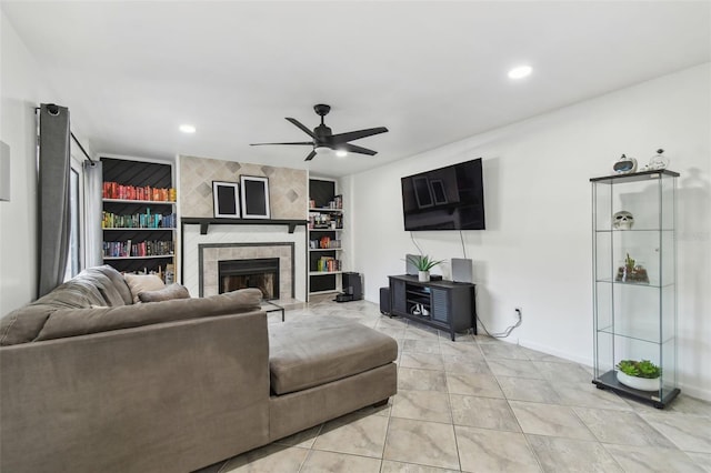 living room with ceiling fan, recessed lighting, a tile fireplace, and built in features