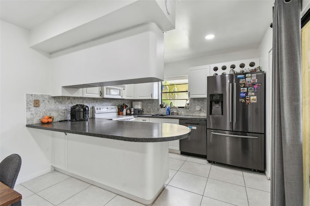 kitchen with light tile patterned floors, dark countertops, backsplash, white appliances, and a peninsula