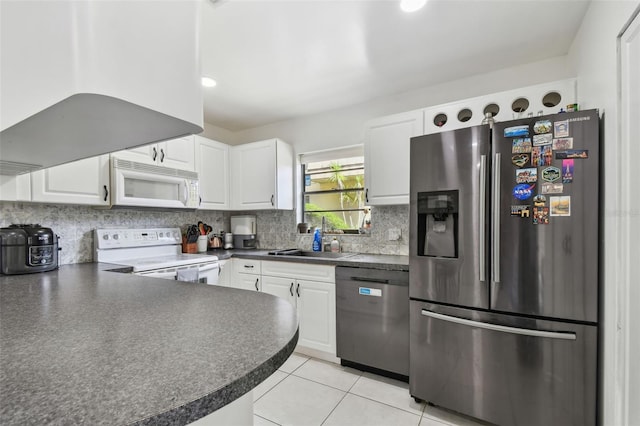 kitchen with dark countertops, tasteful backsplash, stainless steel appliances, and a sink