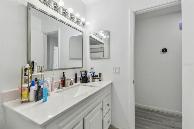 bathroom featuring wood finished floors, vanity, and baseboards