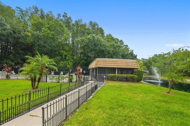 view of home's community with a lawn and fence