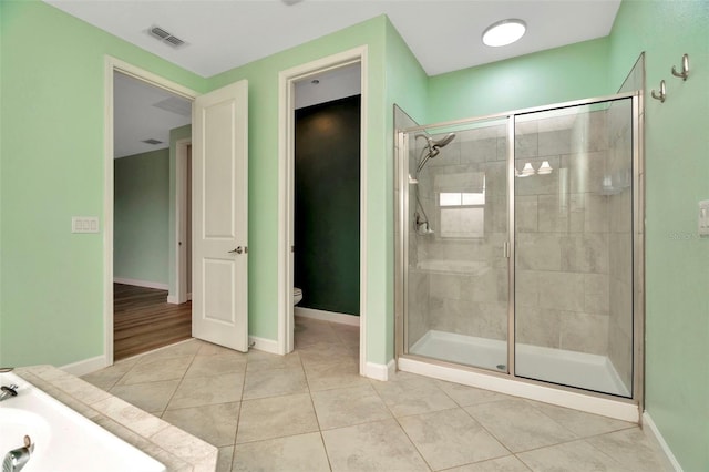 bathroom with baseboards, a stall shower, toilet, and tile patterned floors