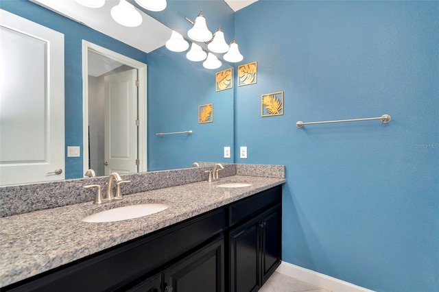 bathroom featuring baseboards, double vanity, a sink, and tile patterned floors