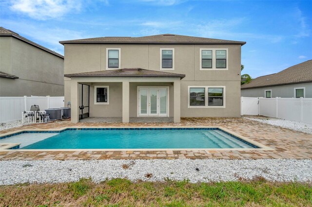 back of property featuring a fenced backyard, french doors, a fenced in pool, stucco siding, and a patio area