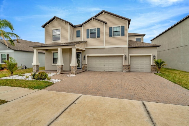 view of front of home with stone siding, covered porch, decorative driveway, and stucco siding