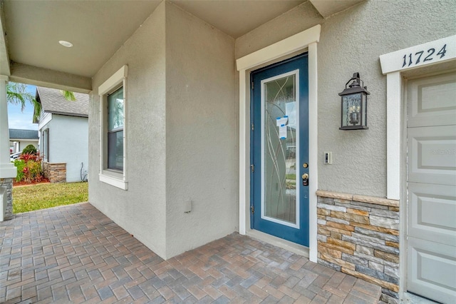 property entrance with stone siding and stucco siding