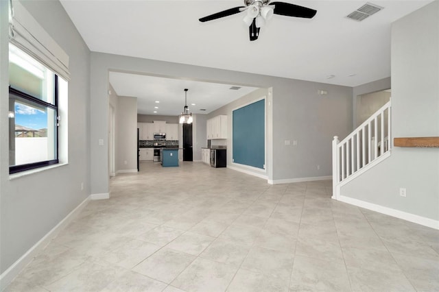 unfurnished living room featuring baseboards, visible vents, ceiling fan, stairs, and light tile patterned flooring