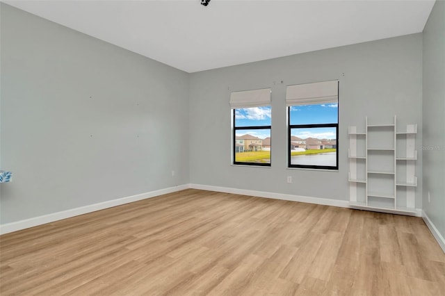 spare room with light wood finished floors and baseboards