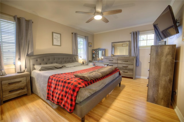 bedroom featuring ornamental molding, multiple windows, and light wood finished floors