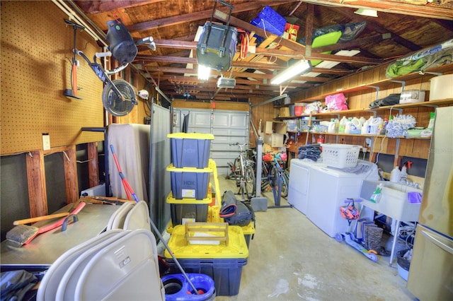 garage featuring washing machine and clothes dryer and a sink