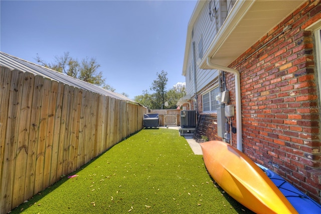 view of yard featuring a fenced backyard and central AC