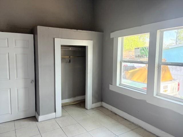 2410 Harper St, Tampa, FL 33605 - unfurnished bedroom featuring baseboards, a closet, and light tile patterned flooring