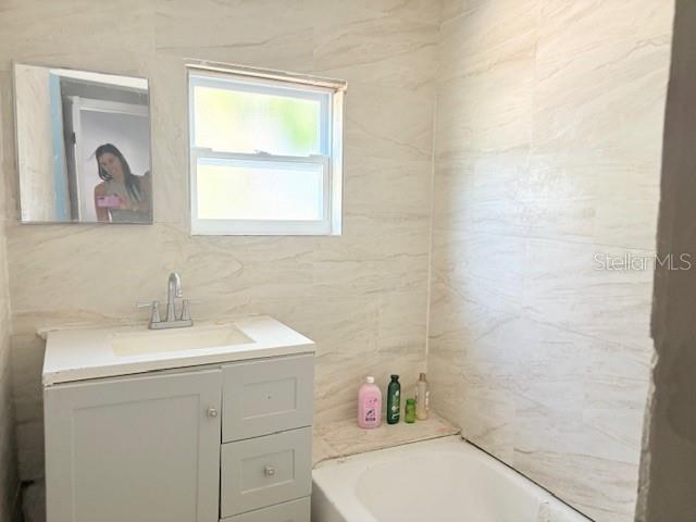2410 Harper St, Tampa, FL 33605 - full bathroom featuring tile walls, vanity, and a bath