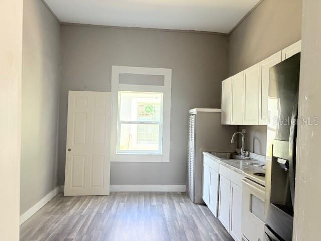2410 Harper St, Tampa, FL 33605 - kitchen with white cabinetry, a sink, baseboards, and range