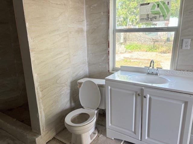 2410 Harper St, Tampa, FL 33605 - bathroom featuring toilet, vanity, plenty of natural light, and tile walls