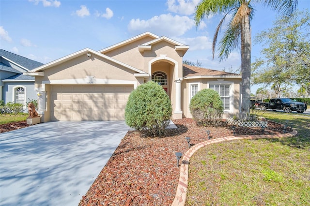 mediterranean / spanish-style home featuring concrete driveway, an attached garage, and stucco siding