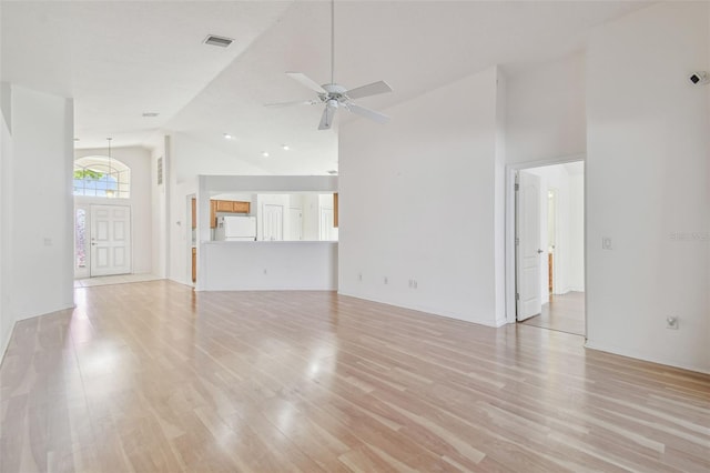 unfurnished living room with light wood-style floors, visible vents, ceiling fan, and high vaulted ceiling