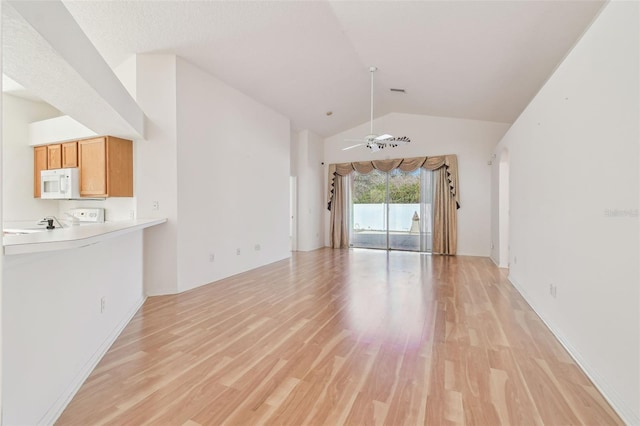 unfurnished living room featuring light wood finished floors, ceiling fan, and vaulted ceiling