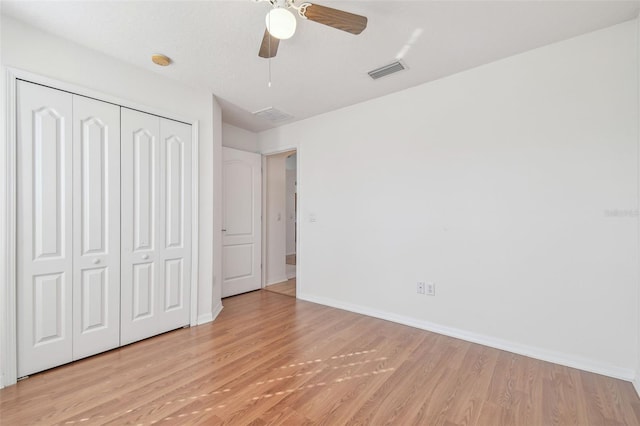 unfurnished bedroom with baseboards, visible vents, a ceiling fan, light wood-type flooring, and a closet