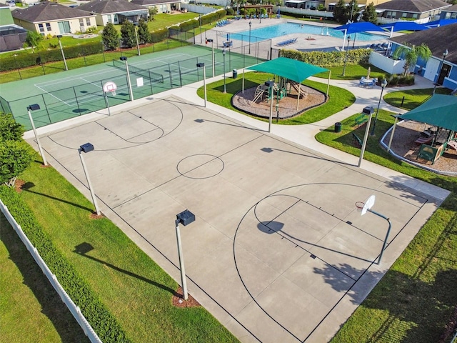 view of sport court with a residential view, playground community, community basketball court, and fence