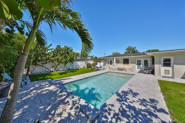 view of swimming pool with a patio, a fenced in pool, a fenced backyard, a lawn, and an outdoor hangout area