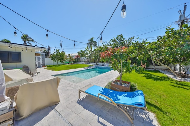 view of swimming pool with a yard, a patio area, and a fenced in pool