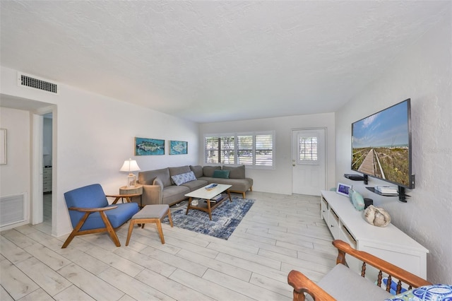 living area featuring visible vents and a textured ceiling