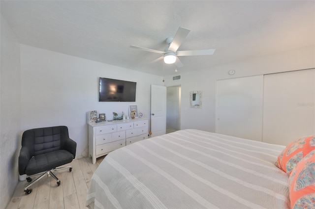 bedroom featuring a closet, visible vents, light wood-type flooring, and ceiling fan