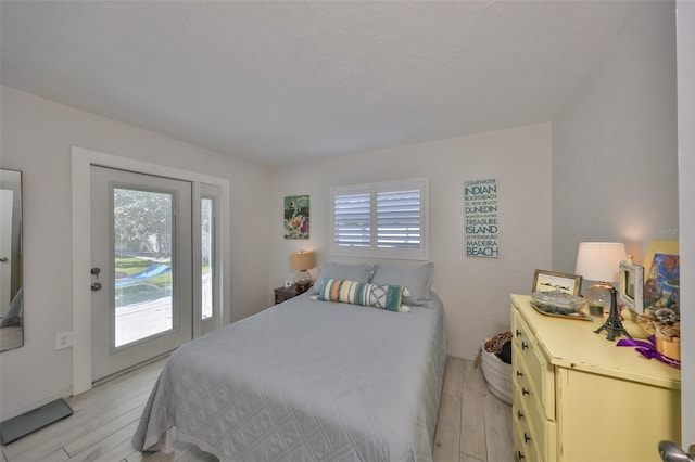 bedroom with light wood-style flooring and access to outside