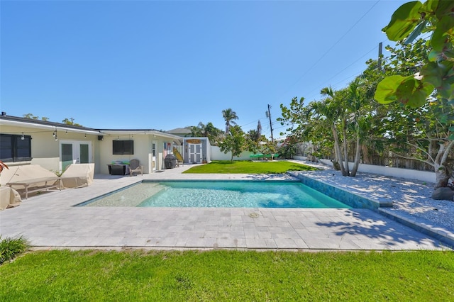 view of pool with a fenced in pool, a lawn, a fenced backyard, and a patio area